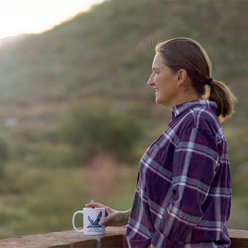 Dr. Kate Huyvaert outside with a cup of coffee
